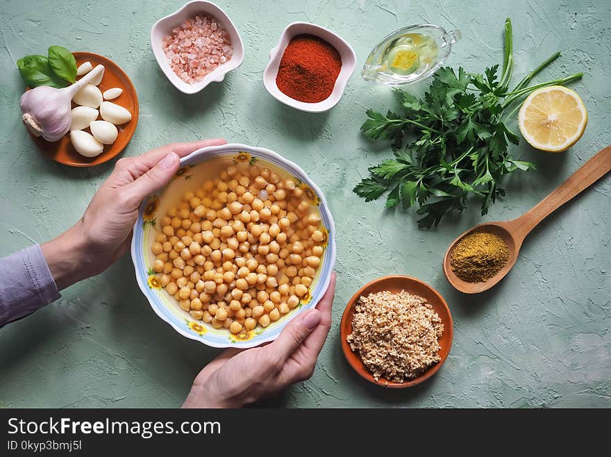 Chickpeas in hand. Ingredients for traditional hummus on the kitchen table.