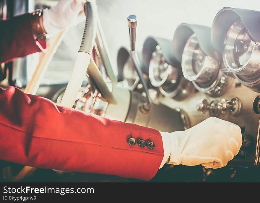 Classic Car Driving Theme. Caucasian Men Wearing White Gloves Taking Vintage Collectible Car on the Test Ride. Hand on the Steering Wheel Closeup Photo.