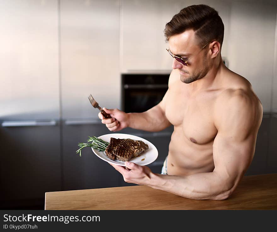 Man ready to eat cut with fork and knife grill beef steak on a kitchen