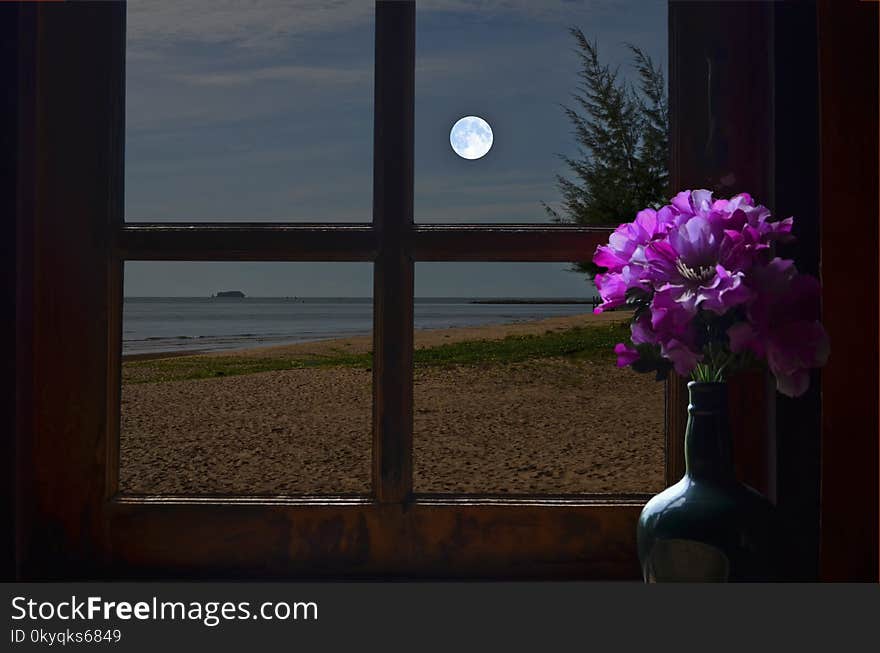 Full moon over the sea in resort window