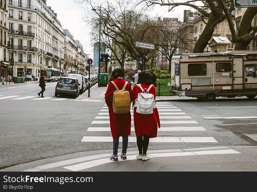 Two Women Wearing Red Coats With Backpacks