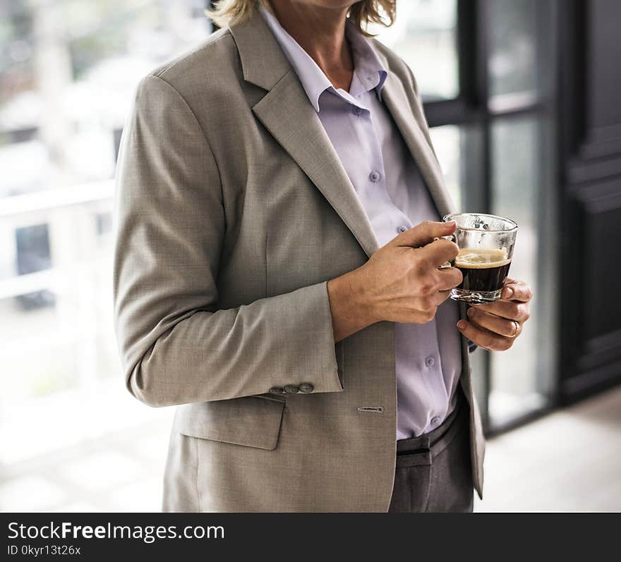 Person Wearing Suit Jacket Holding Glass Mug