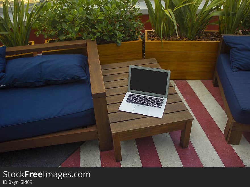 Macbook Air On Brown Wooden Table