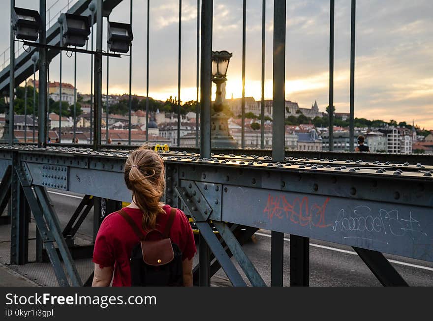 Woman Standing Facing a Bridge