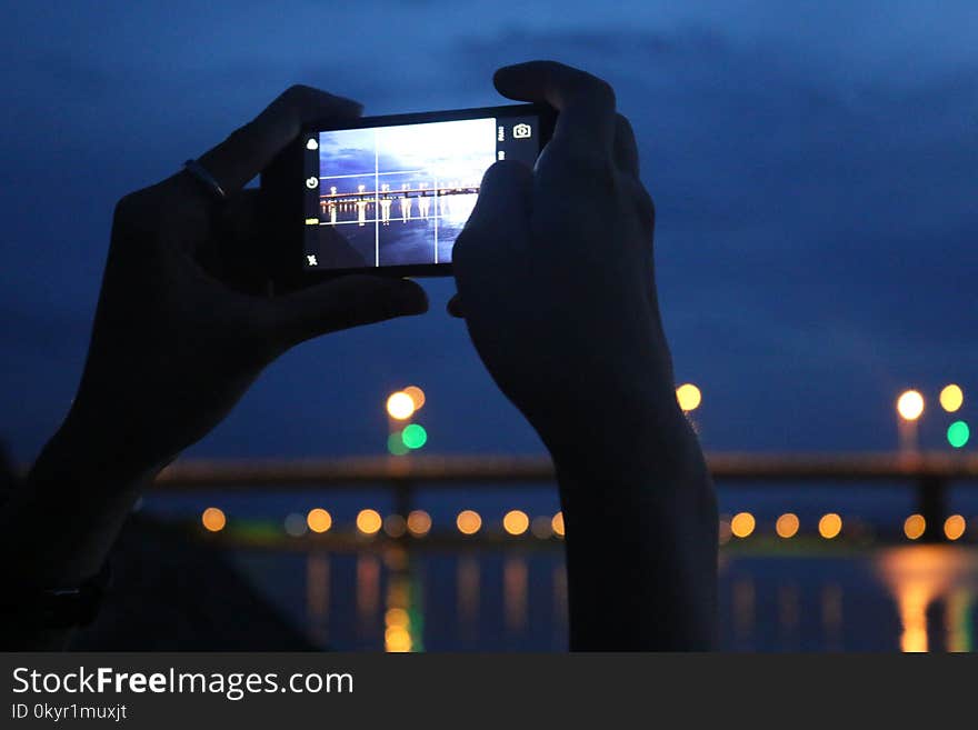 Person Taking A Photo A Of Bridge At Night