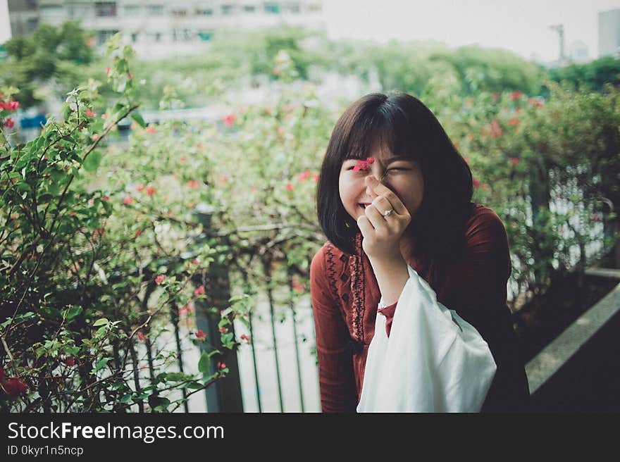 Woman Holding A Red Petaled Flower