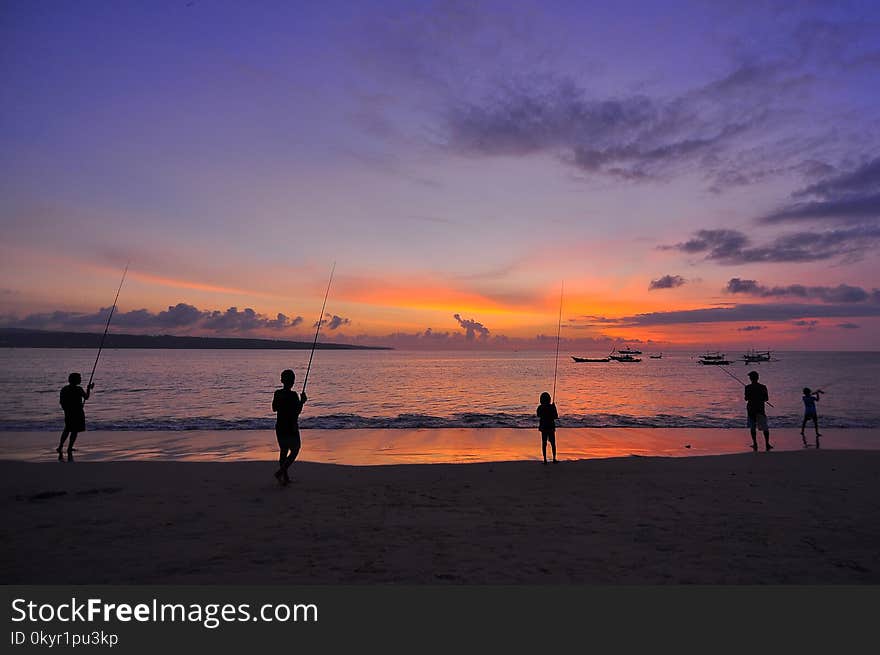 Silhouette Of Five People Standing On Seashore During Sunset