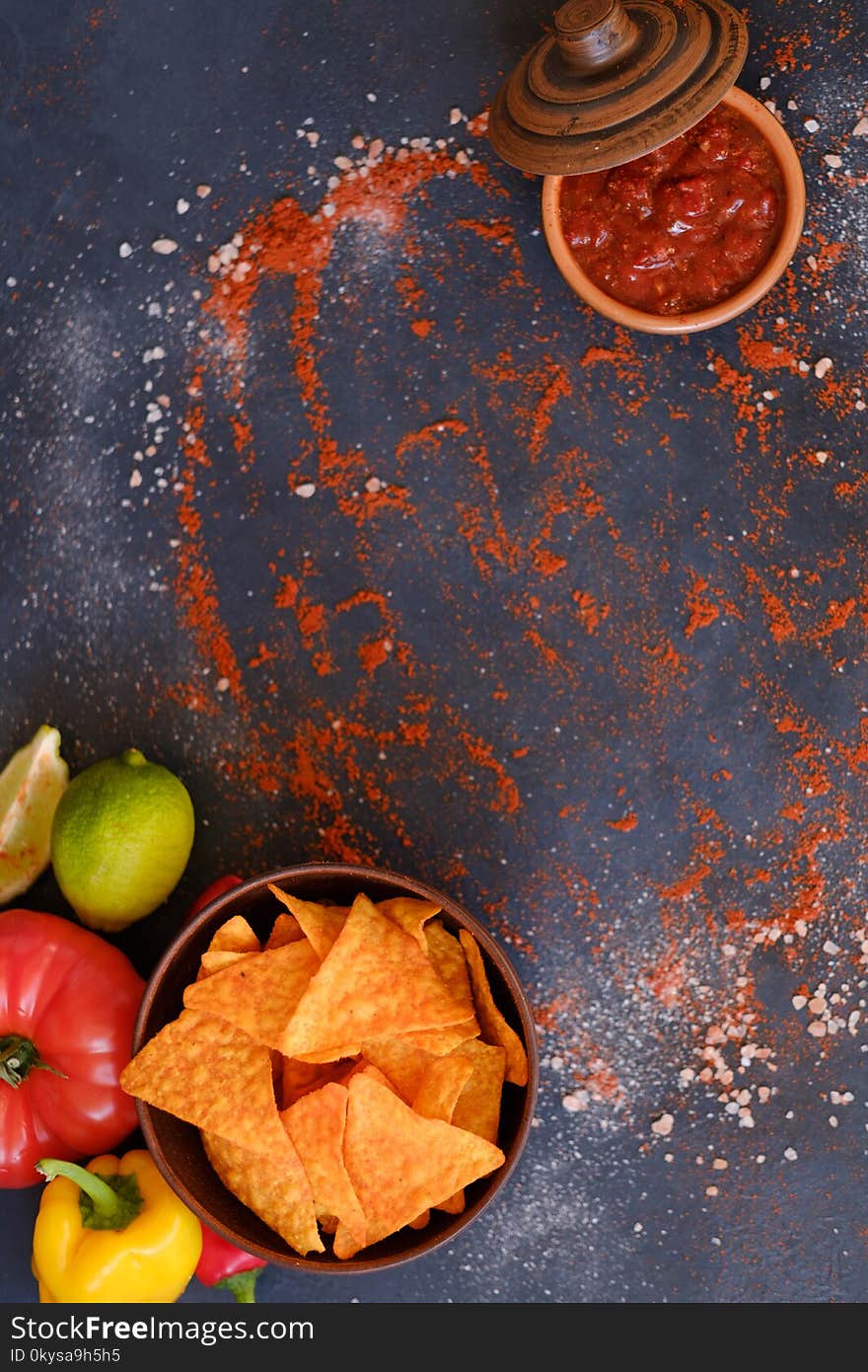 Tortilla nacho chips in a bowl. salsa sauce in a dipping dish. food spices mix background. salty spicy crunchy slices. powdered pepper and salt condiments. Tortilla nacho chips in a bowl. salsa sauce in a dipping dish. food spices mix background. salty spicy crunchy slices. powdered pepper and salt condiments