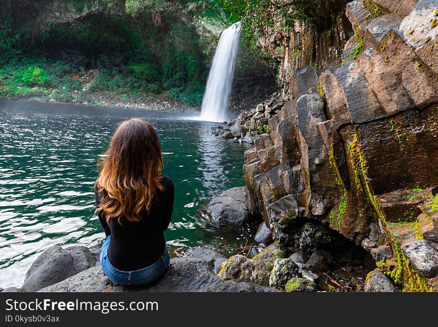 Girl watching the Bassin La Paix waterfall in Reunion Island