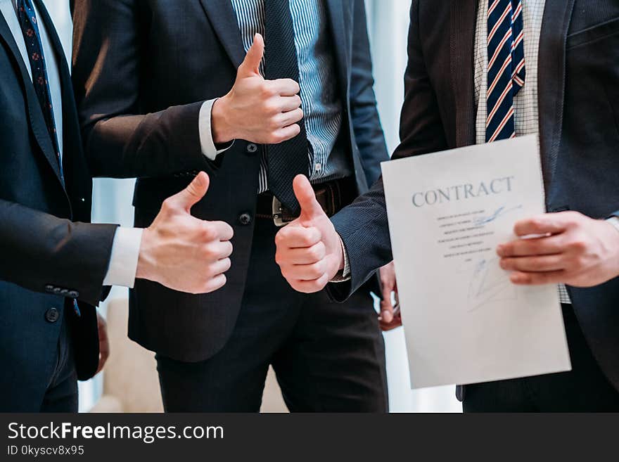 Success cooperation teamwork concept. deal sealing. contract signing. confident business men showing thumbs up. Success cooperation teamwork concept. deal sealing. contract signing. confident business men showing thumbs up.