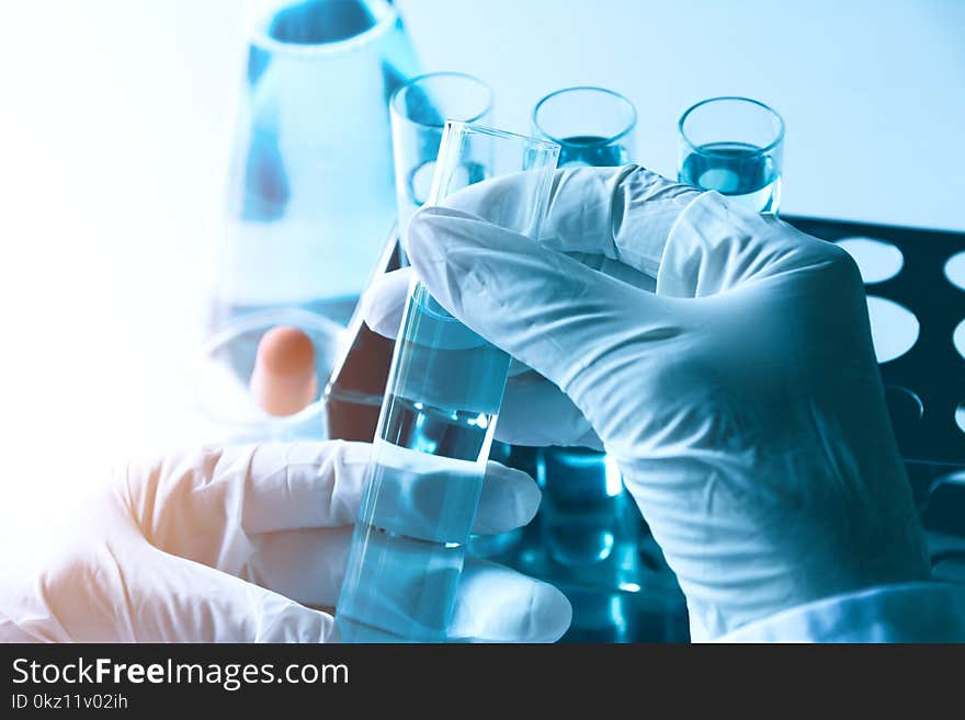 Researcher with glass laboratory chemical test tubes with liquid for analytical , medical, pharmaceutical and scientific research concept.