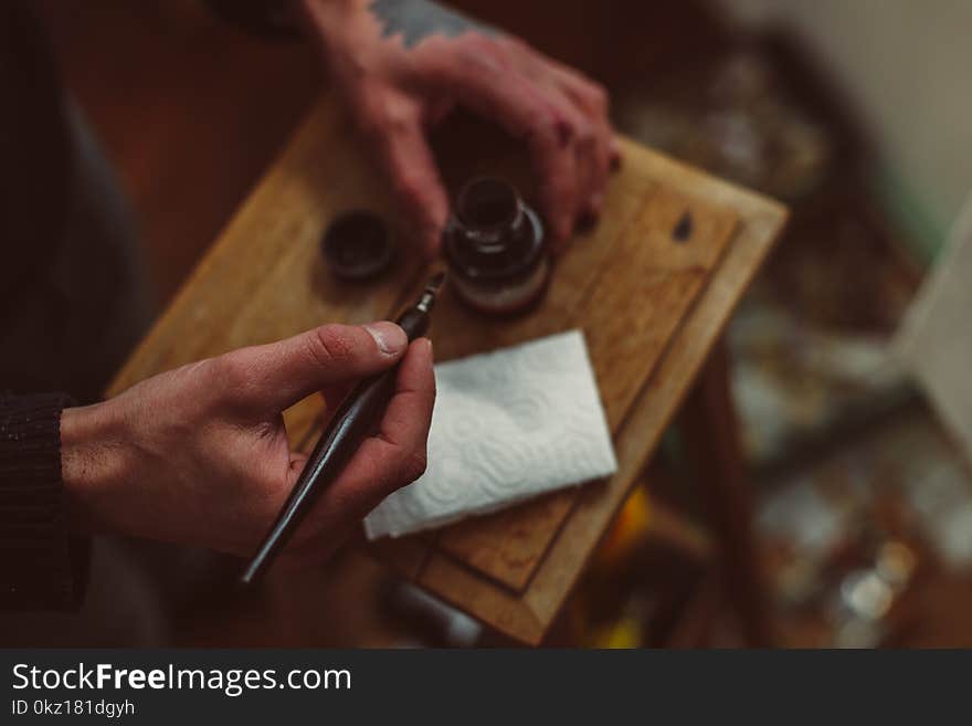 Hands of male artist, pen and ink for drawing on wooden table. Hands of male artist, pen and ink for drawing on wooden table