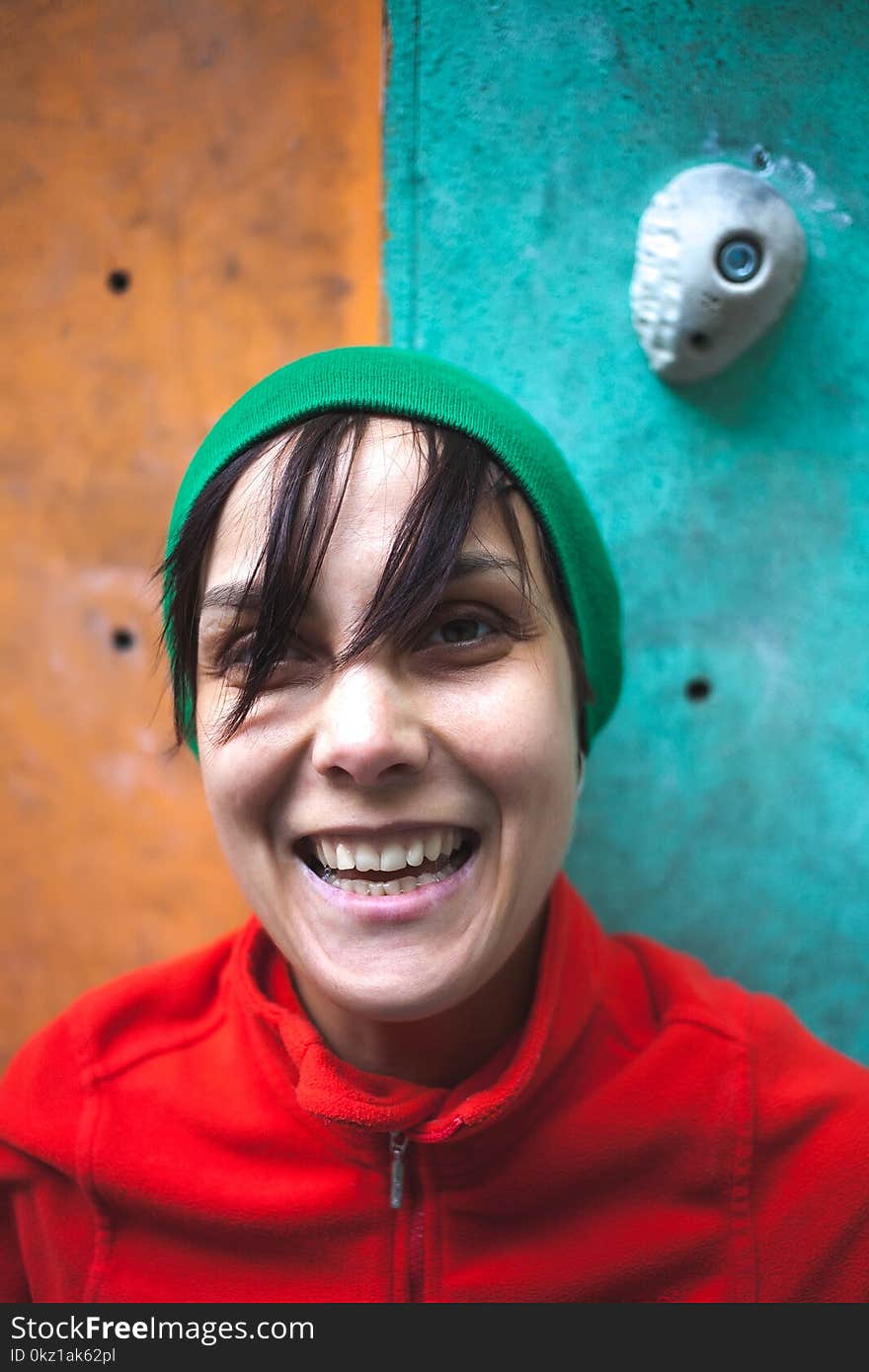 Portrait of a rock climber. A woman trains on a climbing wall. The face of a sportswoman.