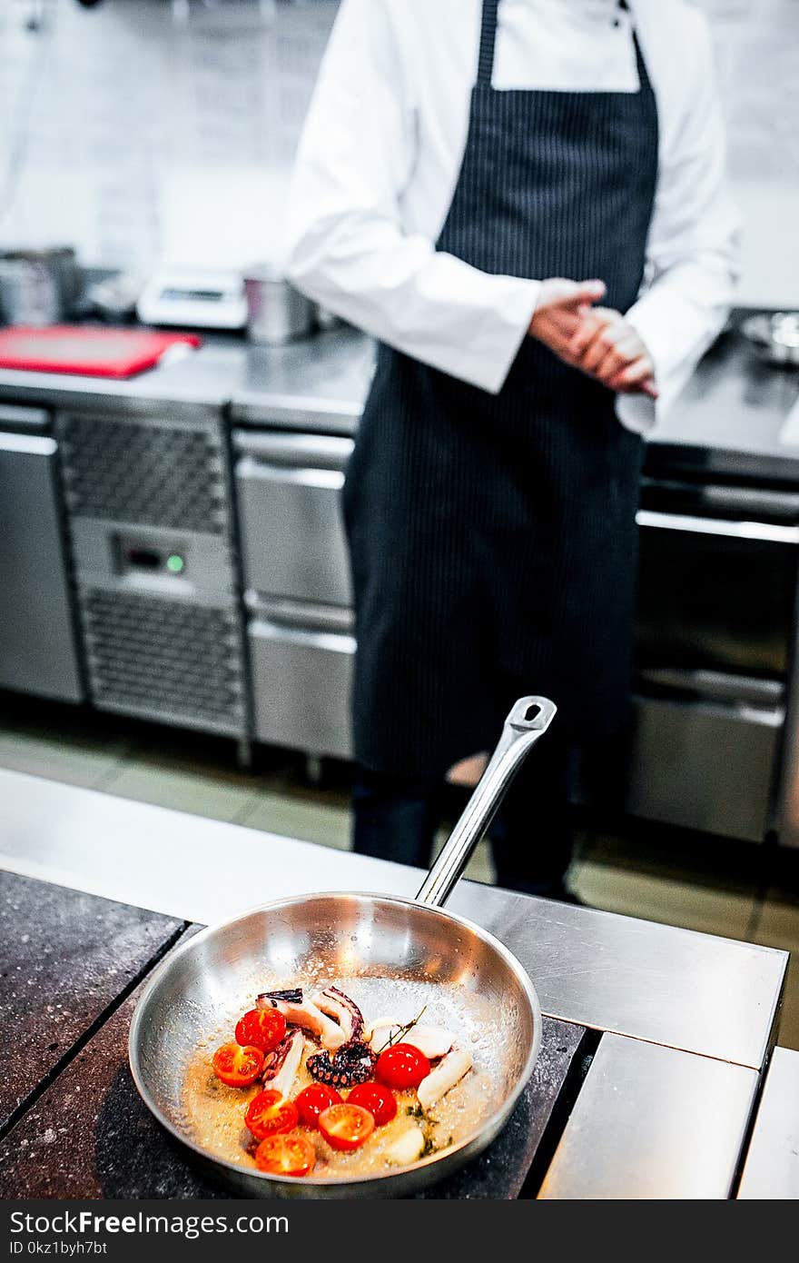 Chef preparing food in the kitchen on pan vertical