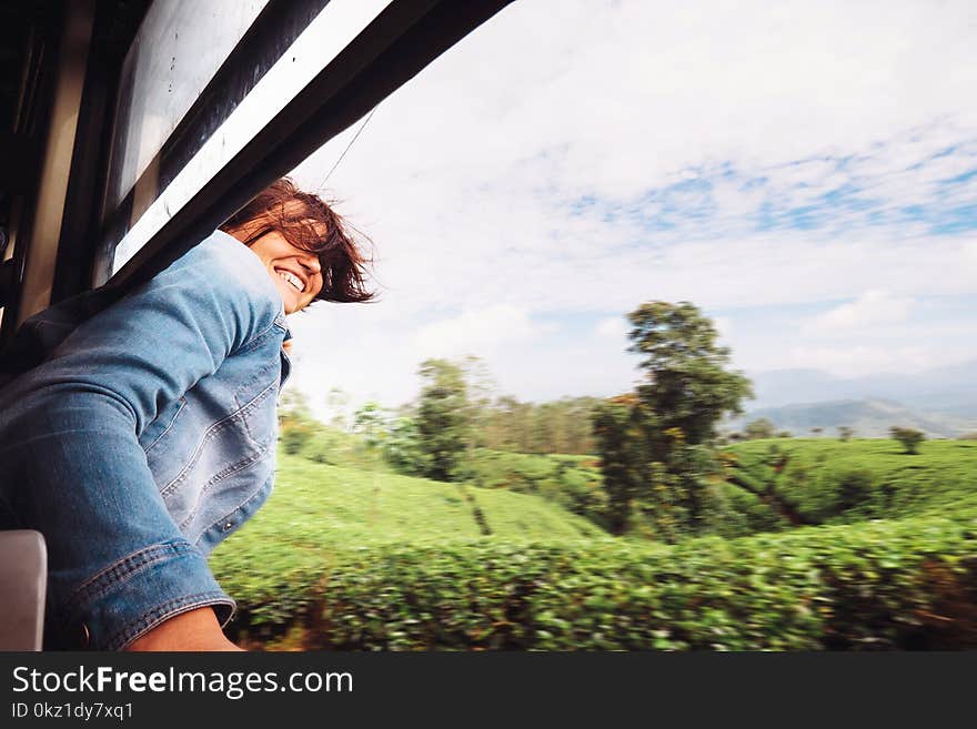 Happy Woman Looks Out From Train Window During Traveling On Most