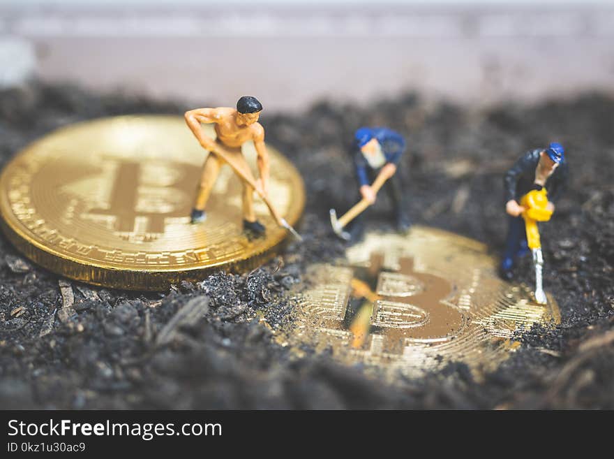 Miniature people : Worker team digging ground to uncover big shiny bitcoin