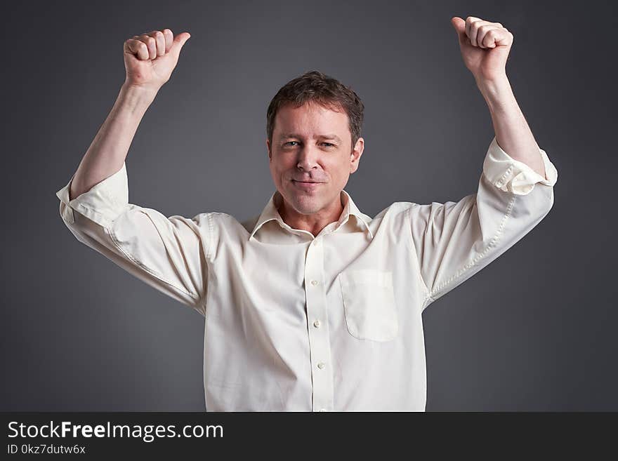 Portrait of a happy middle age man showing thumbs up and celebratingr. Portrait of a happy middle age man showing thumbs up and celebratingr