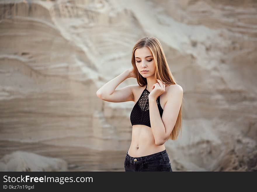 Portrait Of A Beautiful Girl With Long Hair On The Sands In The Nature At Sunset