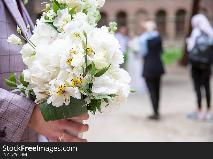 Bride and groom holding wedding white bouquet