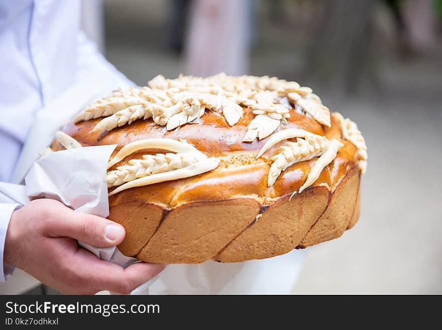 Man walking and holding traditional ukrainian wedding cake with spikelets. delicious loaf. wedding traditions