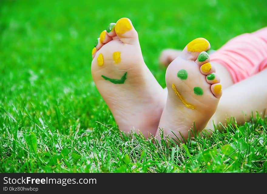 Child Lying On Green Grass. Kid Having Fun Outdoors In Spring Park.