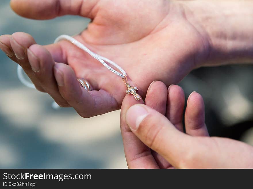 Cross for the rite of baptism in the palm of a man.