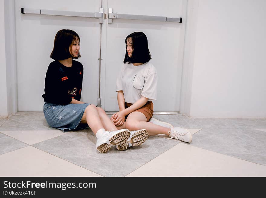 Woman Wearing Gray Crew-neck Shirt Sitting on White and Gray Ceramic Tiles