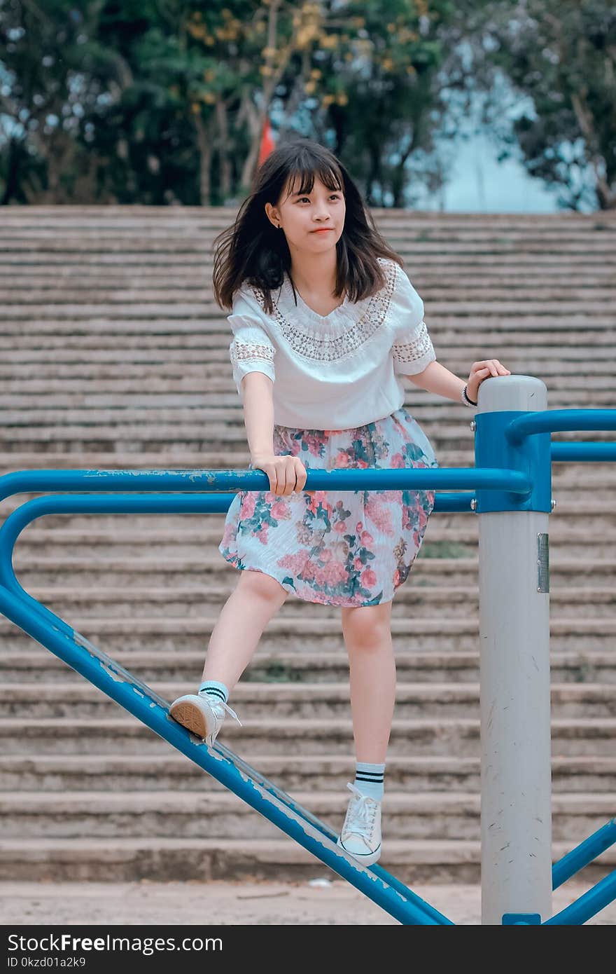 Woman Wearing White Blouse and Multicolored Floral Skirt Riding Merry-go-round