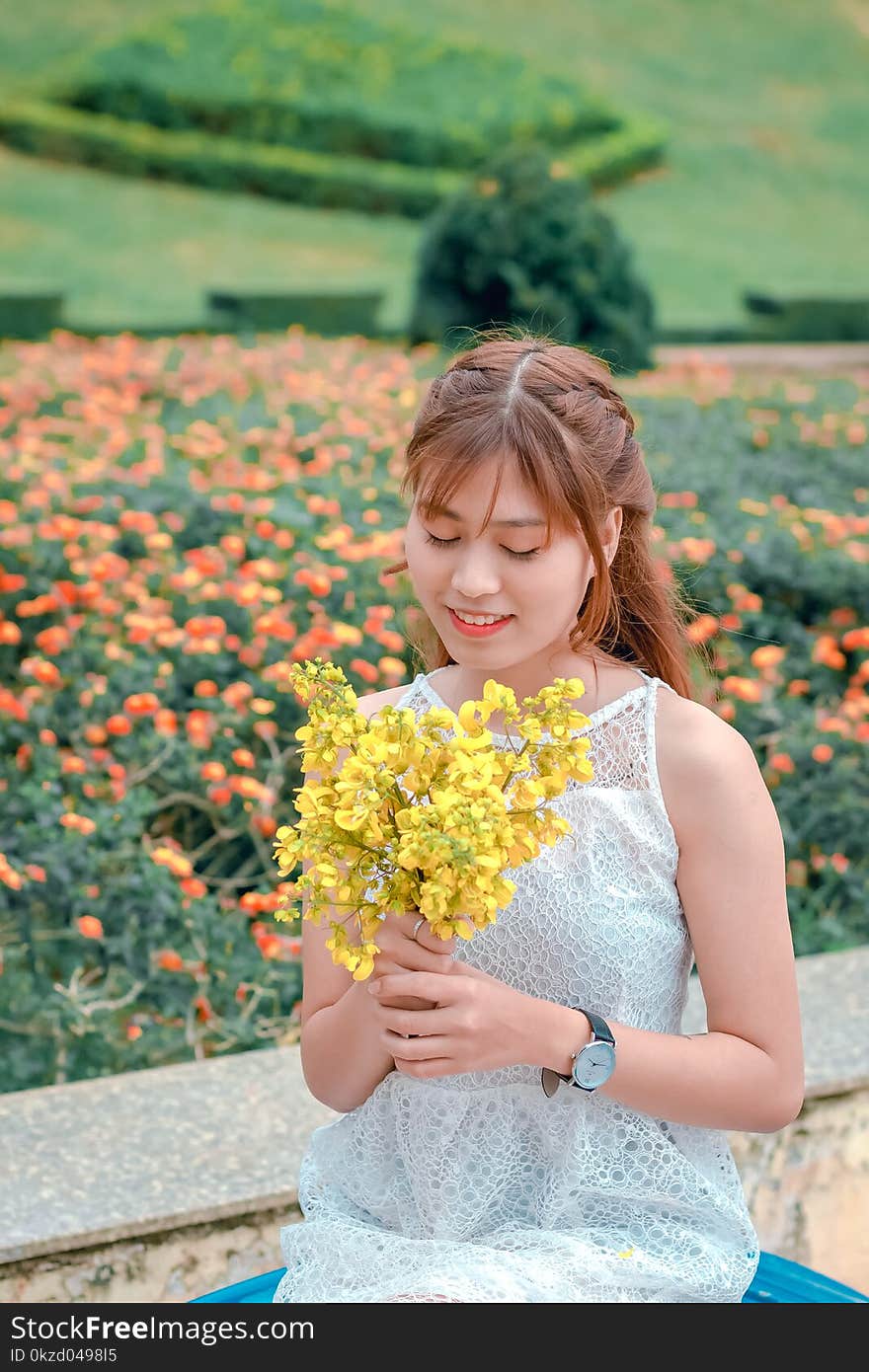 Woman Wearing White Top Holding Yellow Petaled Flowers