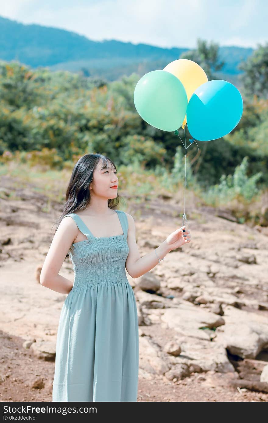 Woman In Dress Holding Balloons