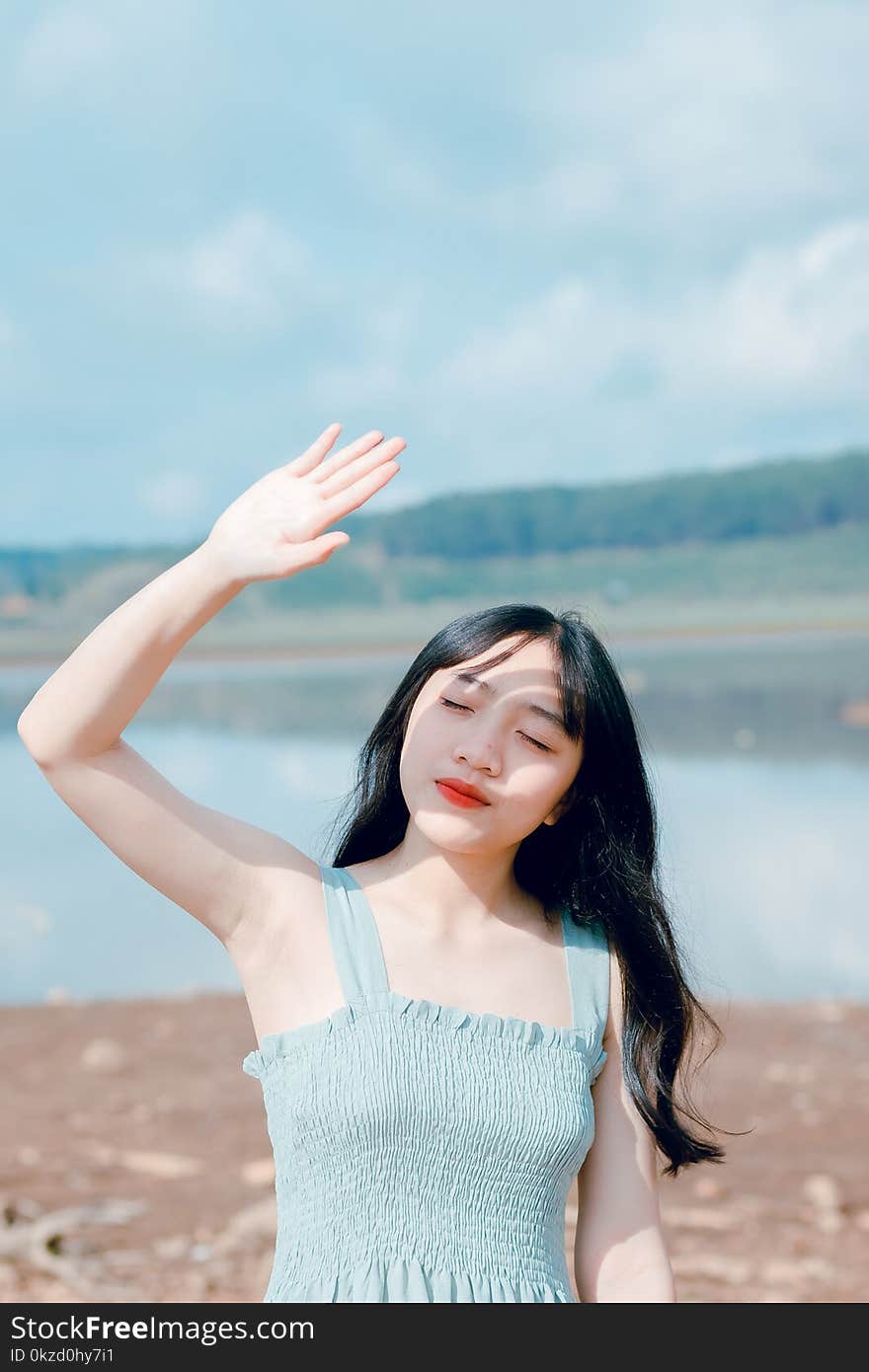 Woman Raising Hand To Cover Sunlight