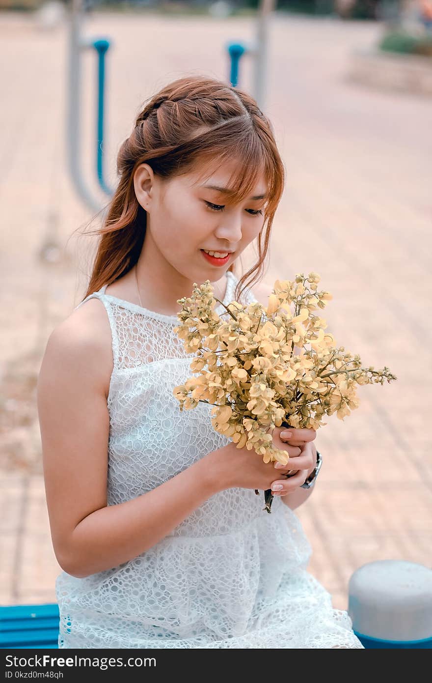 Woman Wearing White Lace Dress Holding Yellow Flower Bouquet