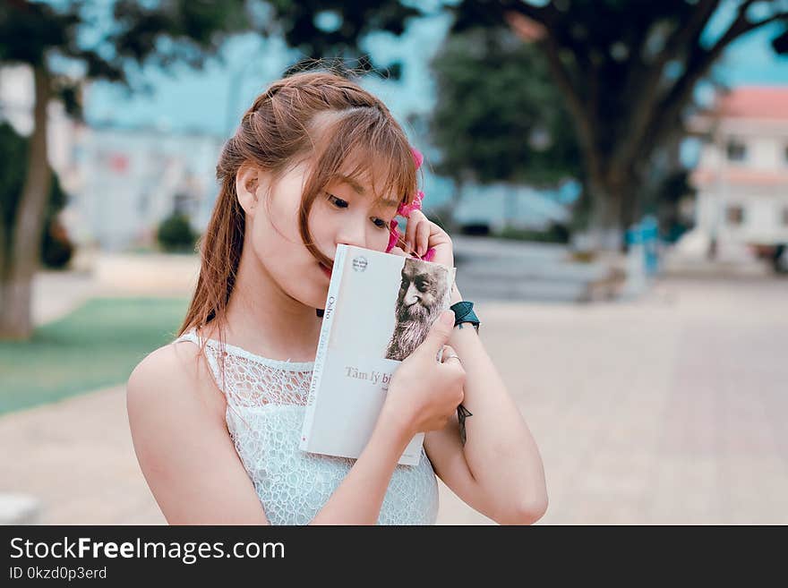 Woman Wearing White Lace Top Holding Book