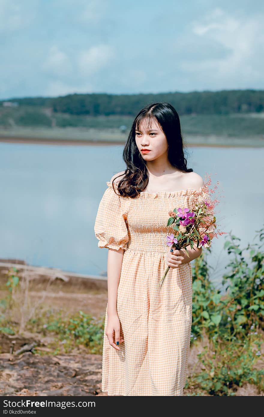 Shallow Focus Photography of Woman in Yellow Off-shoulder Dress Holding Flower Bouquet