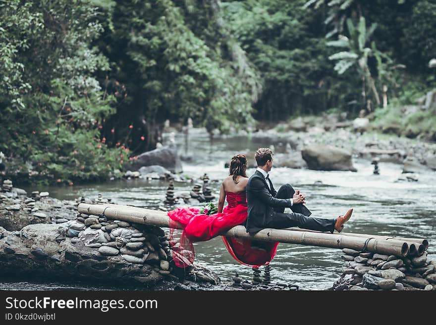 Man And Woman Sitting On Bamboos