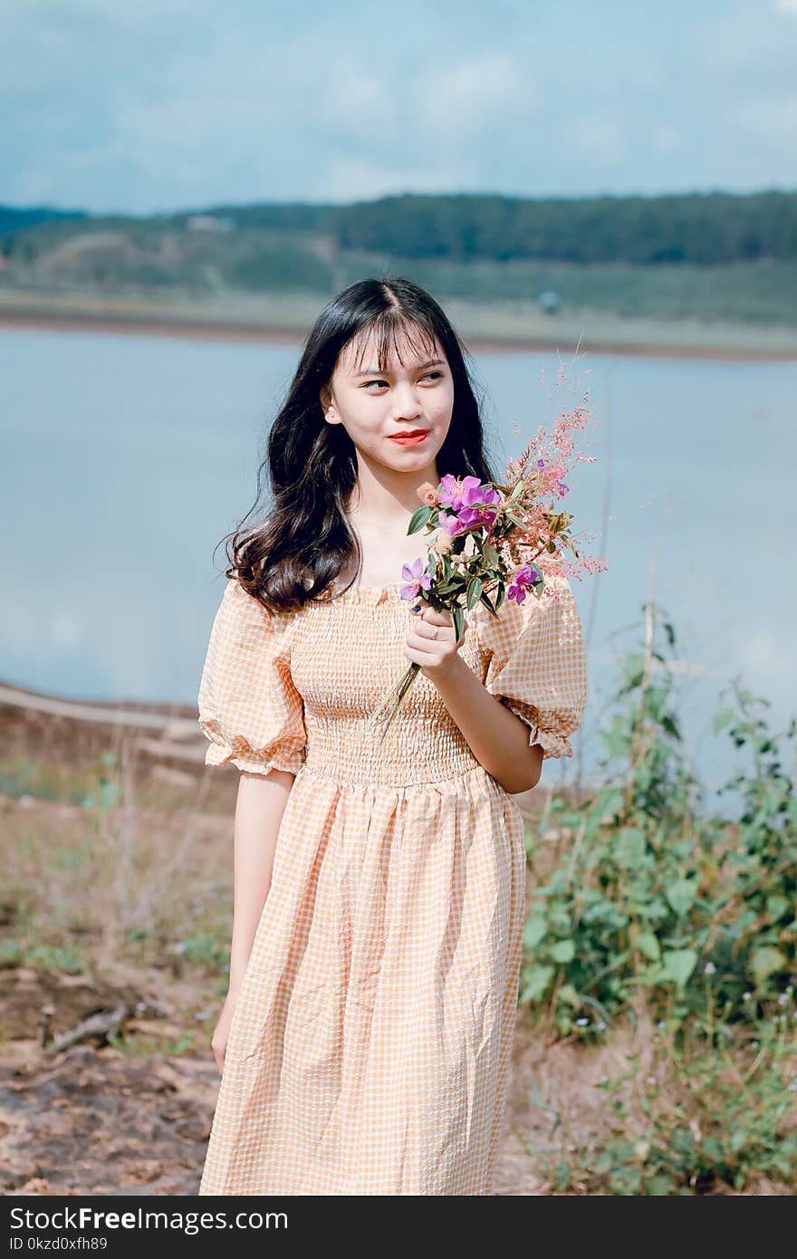 Woman Holding Purple Petaled Flowers