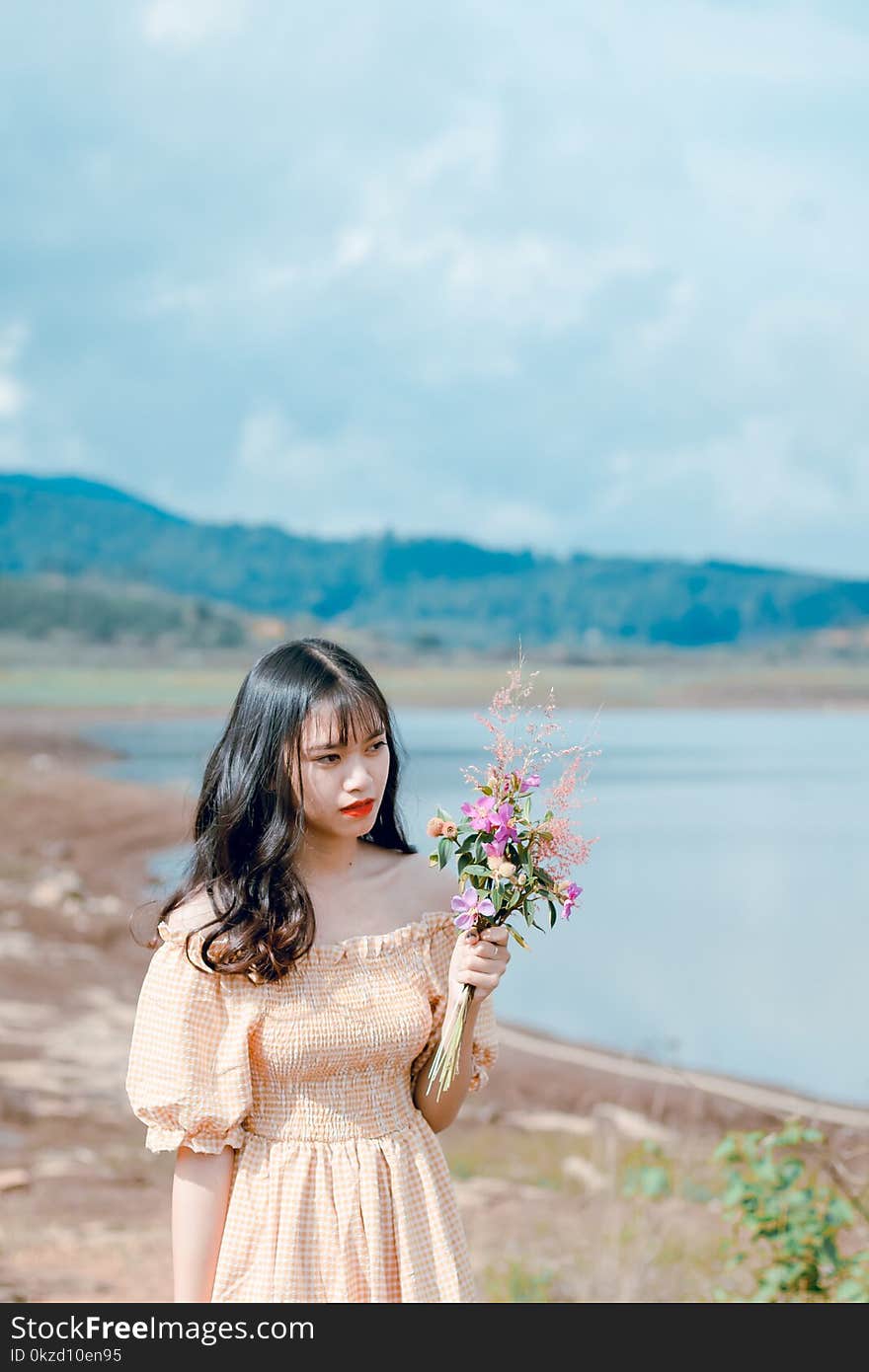 Photography of a Woman Holding Flowers