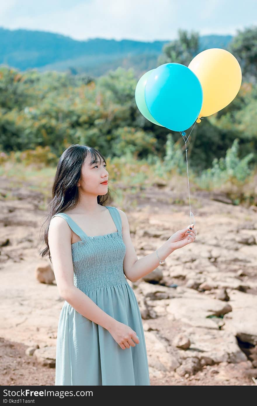 Woman Wearing Blue Dress Holding Balloons