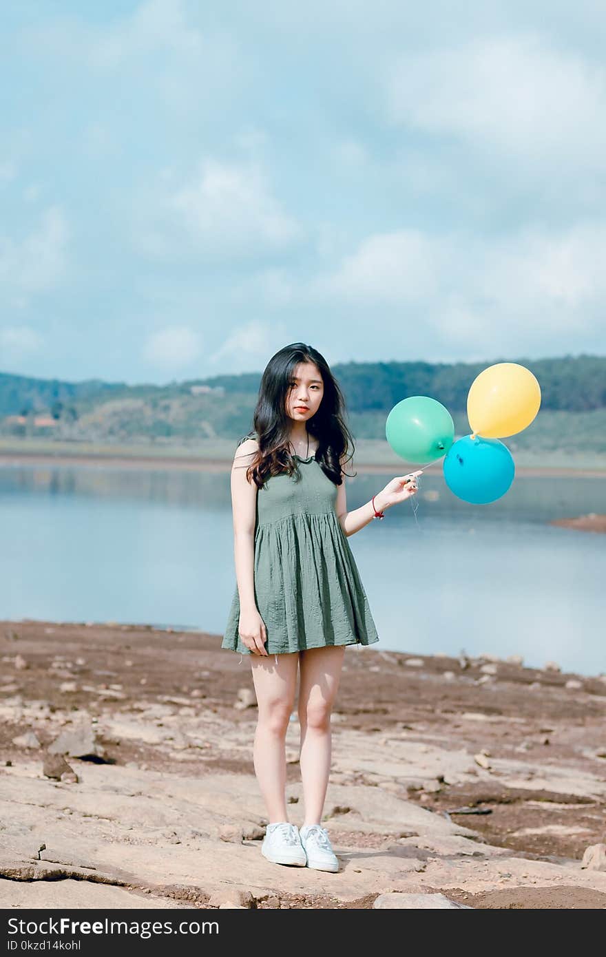 Photo of Girl Wearing Green Mini Dress Holding Balloons