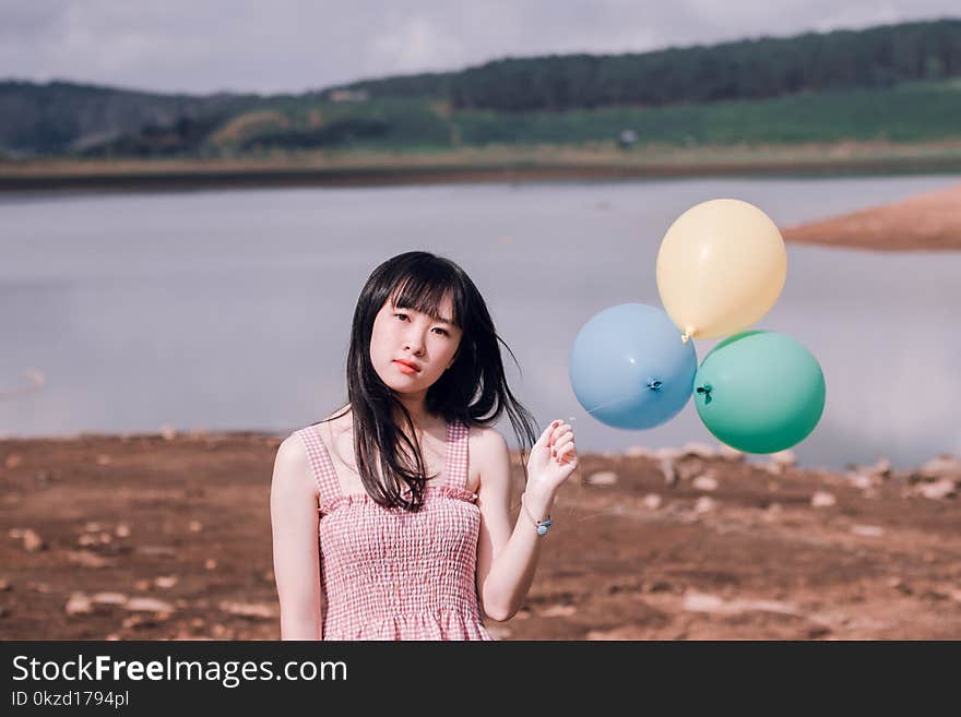 Girl in Pink Sleeveless Top Holds Three Party Balloons