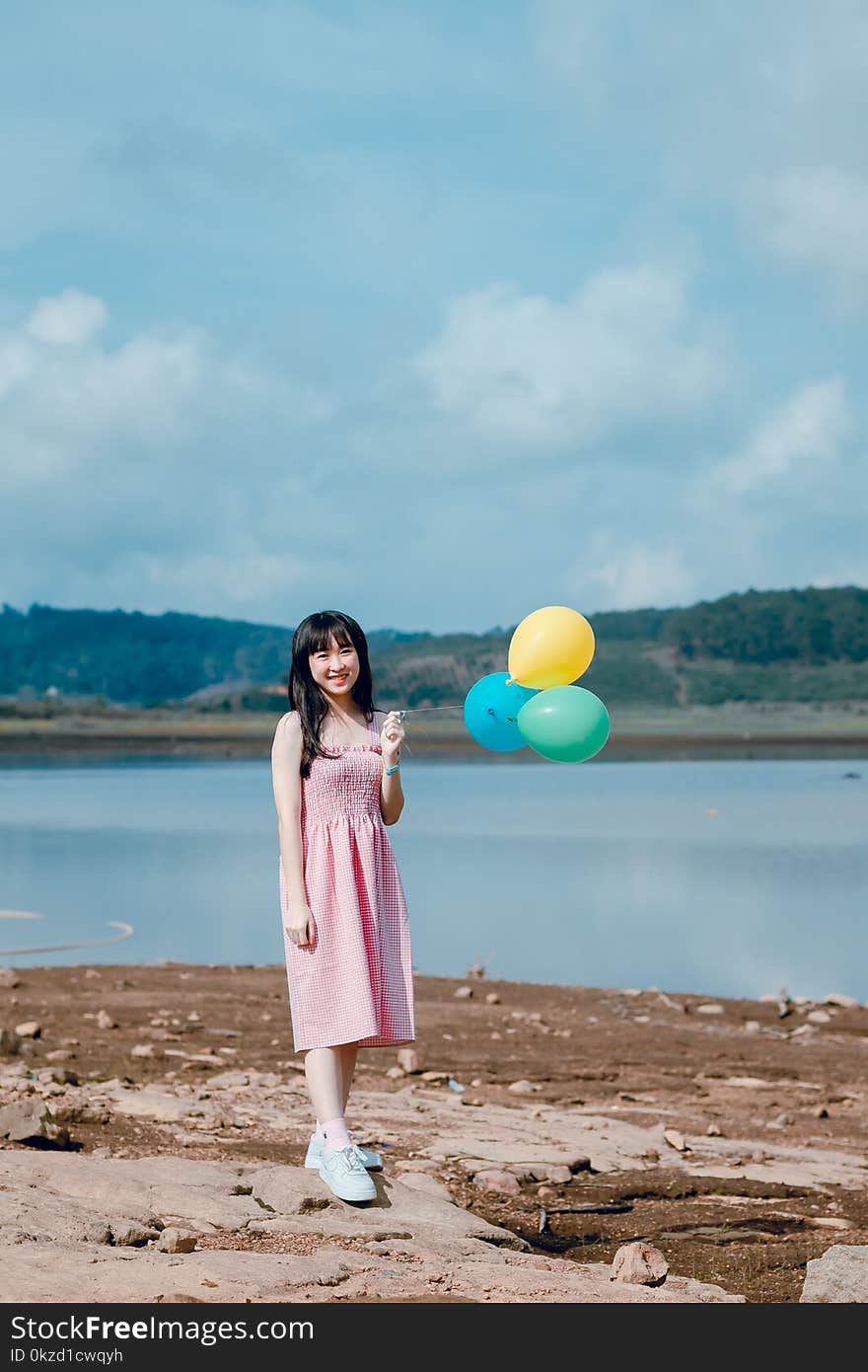 Woman in Pink Dress Holding Balloons