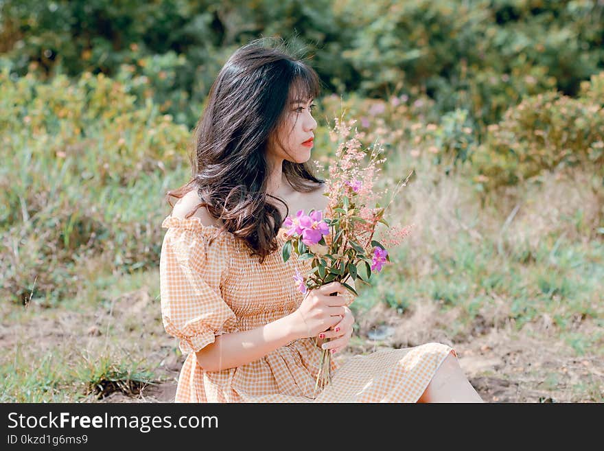 Woman In Dress Holding Flowers