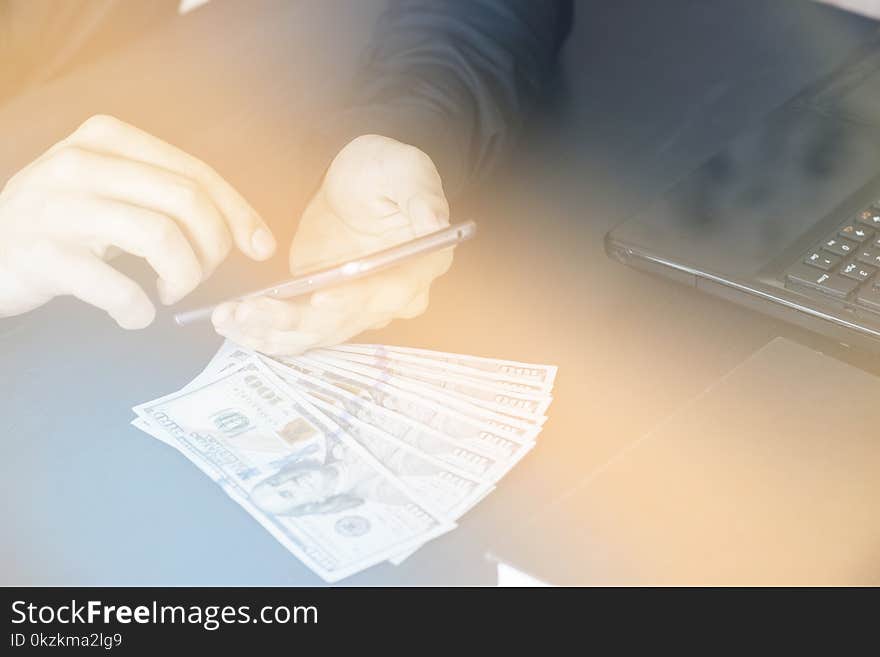 Technology, online banking, money transfer, e-commerce concept. Businessman using smartphone dollar bills flying on grey wall background. Internet earnings concept. Technology, online banking, money transfer, e-commerce concept. Businessman using smartphone dollar bills flying on grey wall background. Internet earnings concept