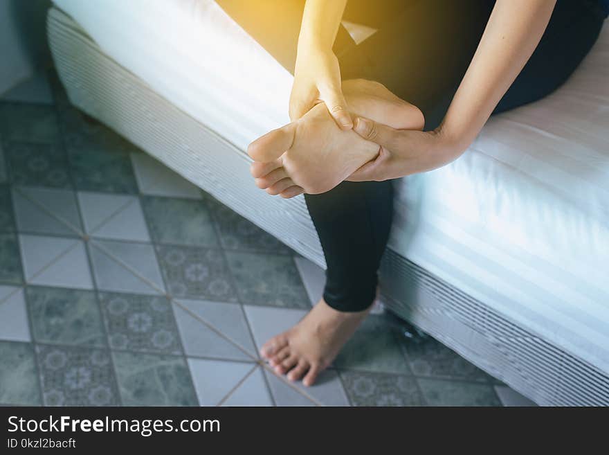 Hands woman touching massage to her foots in bed-room,Healthcare foot soles massage