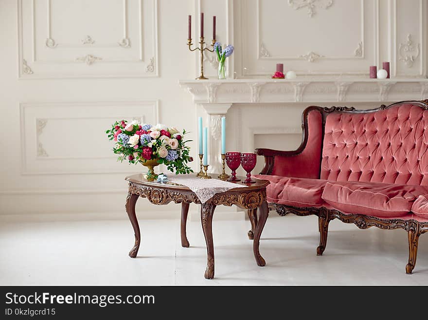 Baroque style interior with red luxury sofa and table in the middle