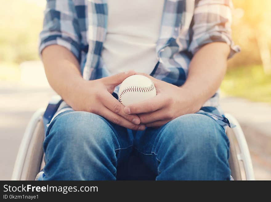 Sports games. Nice disabled person sitting in the armchair and holding a tennis ball while wanting to play. Sports games. Nice disabled person sitting in the armchair and holding a tennis ball while wanting to play