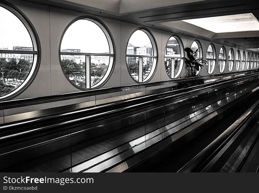 Black and white photo of airport walkway for faster and more efficient travel, composition with straight and cirular round lines. Black and white photo of airport walkway for faster and more efficient travel, composition with straight and cirular round lines