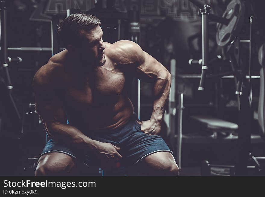 Brutal strong bodybuilder athletic men pumping up muscles with d