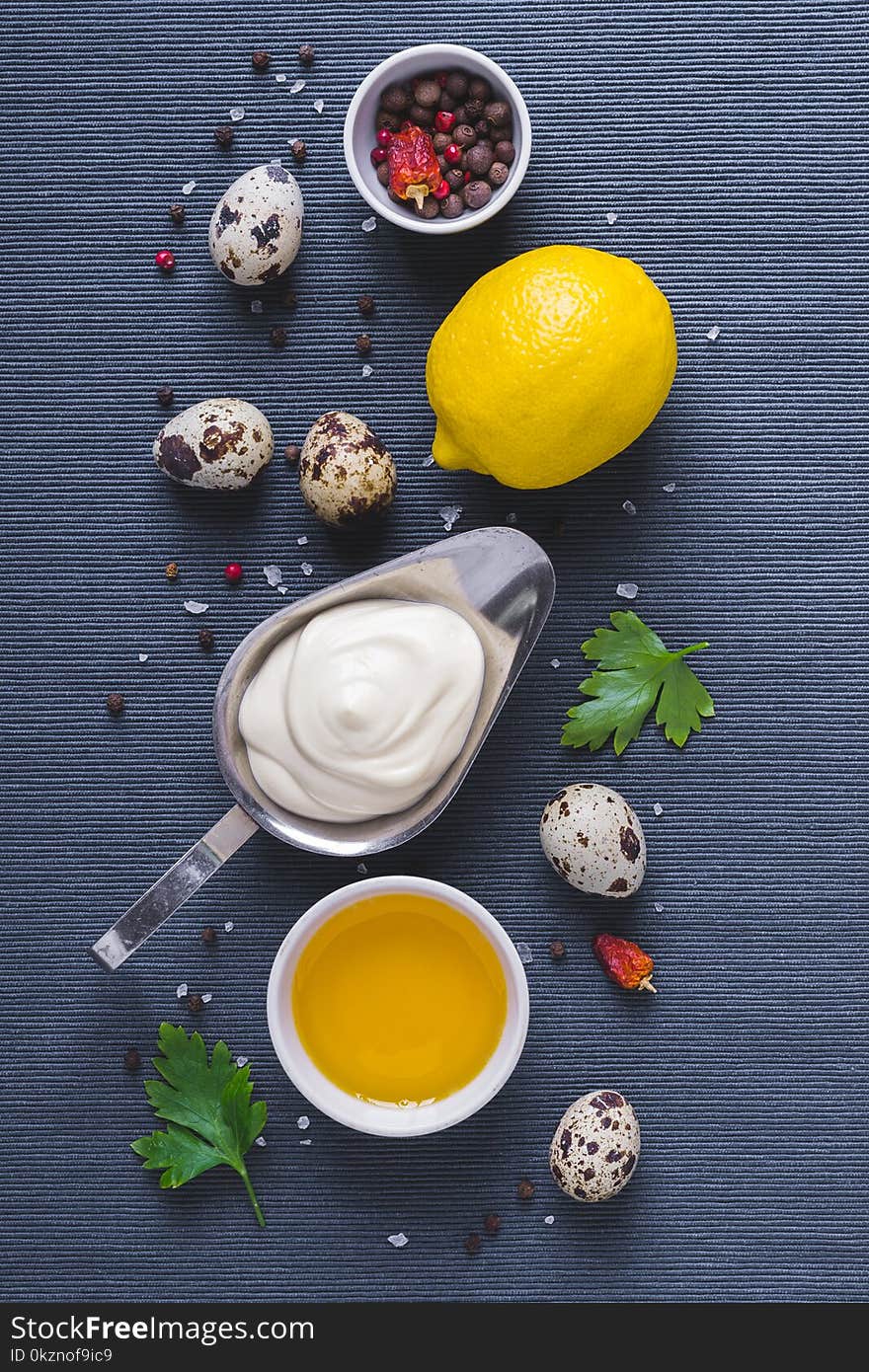 Mayonnaise sauce and ingredients on blue cloth background