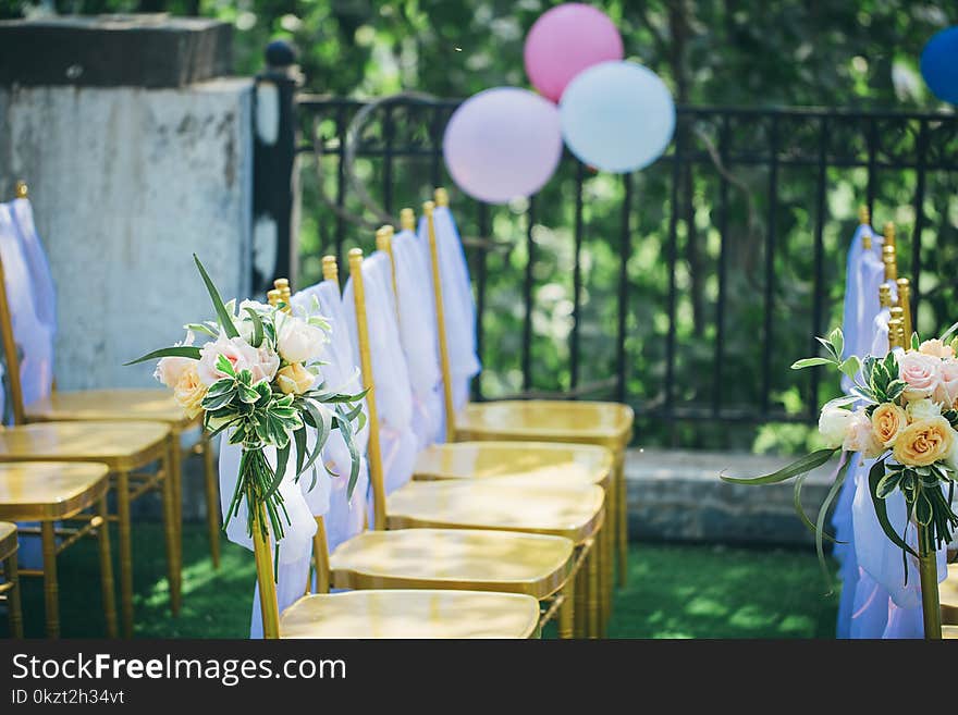 From the picture we can see that this is an outdoor wedding chair, usually called a slub chair with a beautiful color, a bouquet on a chair, and a background with a balloon to show a small scene for an outdoor wedding. From the picture we can see that this is an outdoor wedding chair, usually called a slub chair with a beautiful color, a bouquet on a chair, and a background with a balloon to show a small scene for an outdoor wedding.